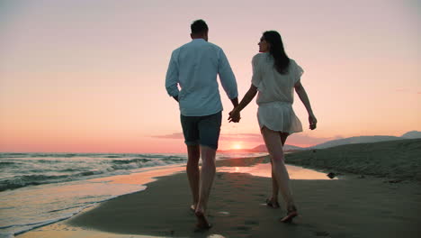 couple walking on the beach at sunset