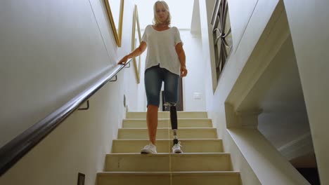 mujer discapacitada con una pierna protésica bajando las escaleras 4k