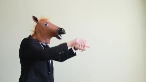 crazy young man in a horse mask dancing rhythmically on a white background crazy young man in a horse mask dancing rhythmically on a white background slow motion the holiday of happiness horse face positive emotions