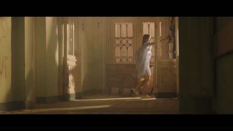 a girl and strange clown on stilts in a dark corridor at night