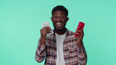 Happy-african-american-man-mobile-phone-display-sincerely-rejoicing-win,-receiving-money-dollar-cash