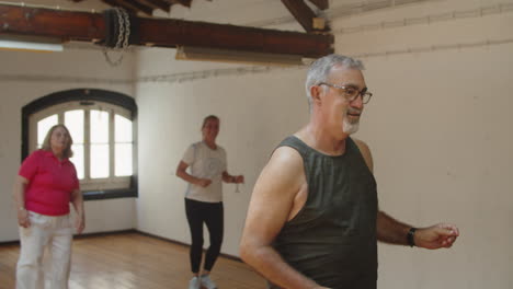 Tracking-shot-of-happy-senior-man-dancing-in-ballroom