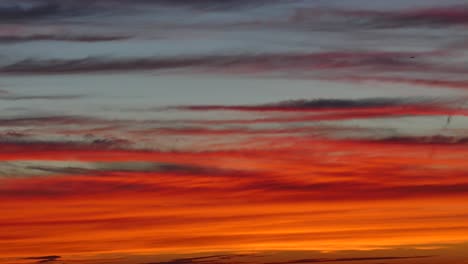 Dramatische-Wolken,-Die-Sich-Während-Eines-Wunderschönen-Orangefarbenen-Sonnenuntergangs-Am-Himmel-Bewegen