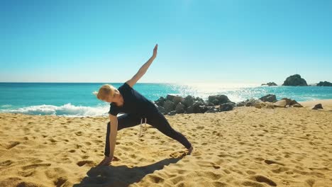 Woman-practicing-balance-yoga-asana-on-coast-of-sea.-Fit-girl-in-yoga-pose