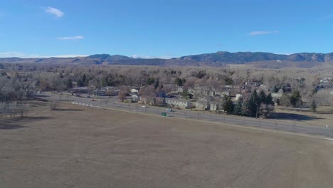 Vuelo-De-Drones-De-Fort-Collins-Colorado-Frente-A-Las-Montañas-Rocosas-En-Un-Cielo-Azul-Y-Mañana-Cálida-Y-Nebulosa-En-Diciembre-De-2020-Durante-La-Pandemia