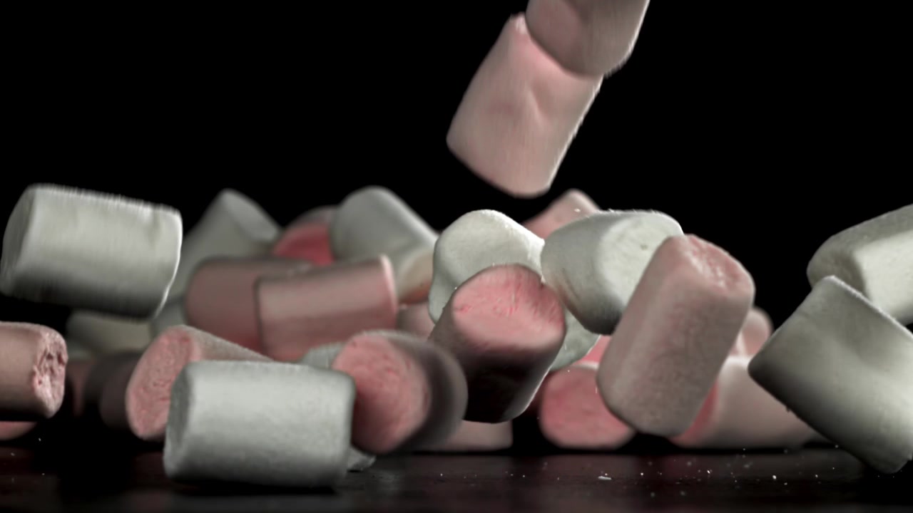 Marshmallow rosa e bianchi che cadono al rallentatore