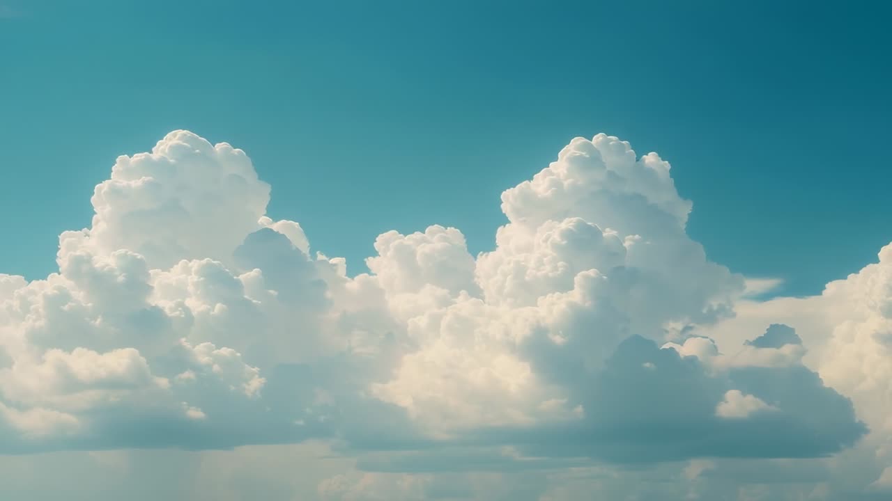 Swelling massive cumulus cloud formation drifting rightward across teal sky, sun heating driving