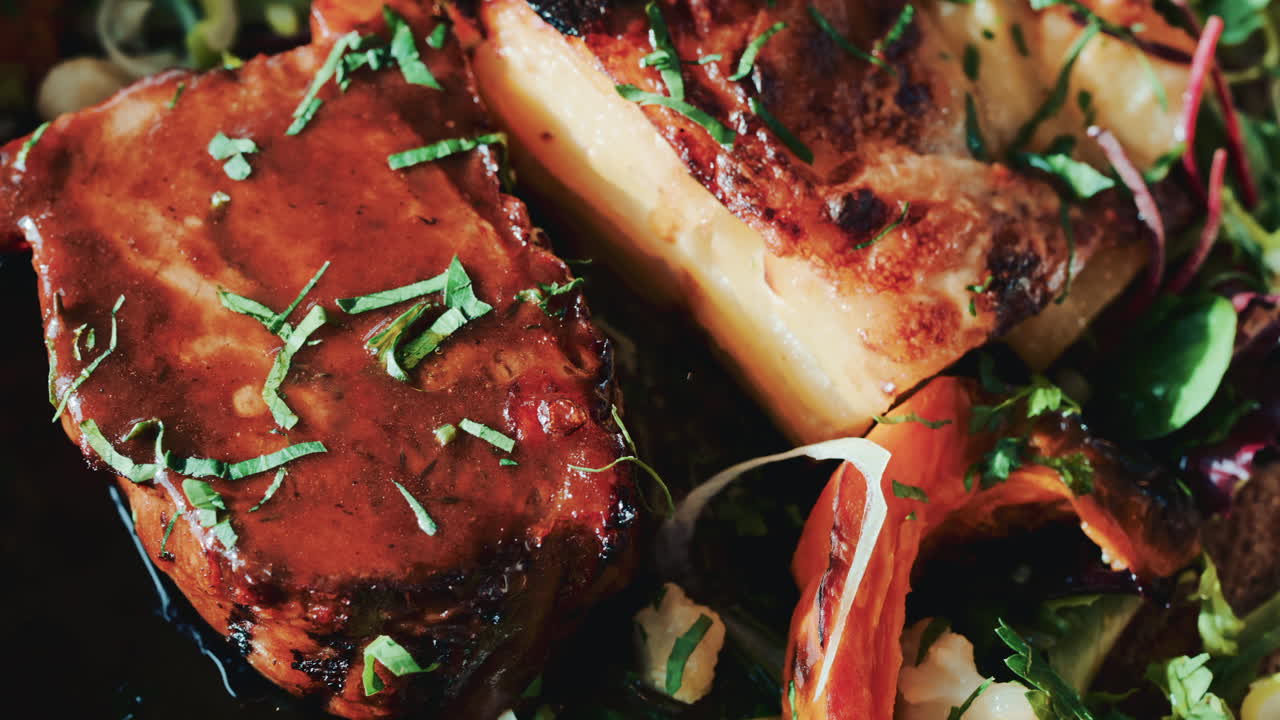 Close up of a gourmet meat dish with grilled vegetables, herbs, and rich sauce
