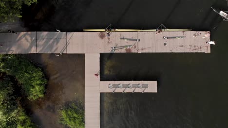 aerial top down view passing a rowing dock and training facility in the city lake of rio de janeiro with rowers arriving and coming out of the water