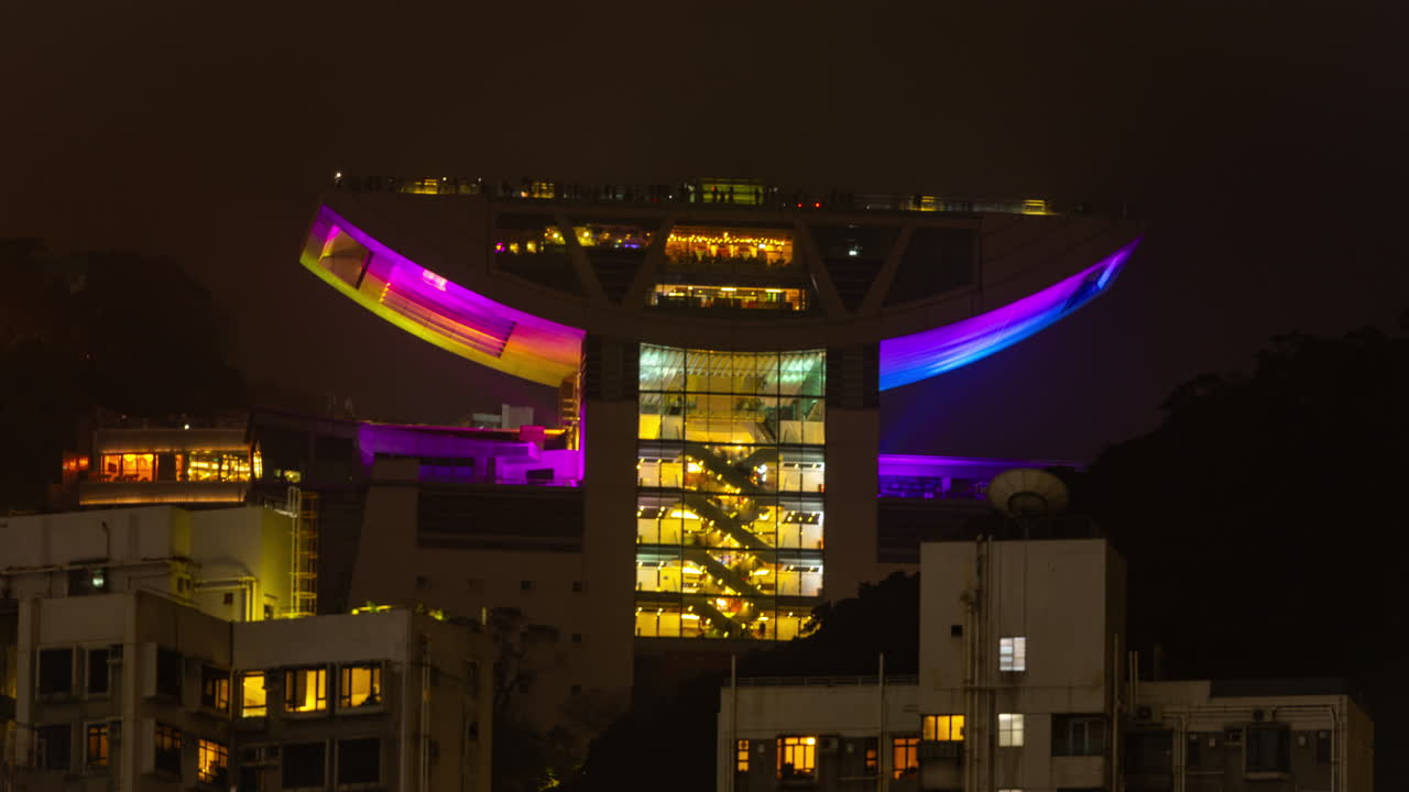 HONG KONG - 19 MARCH 2025 : Timelapse of the Hong Kong city skyline at night with the peak in the background