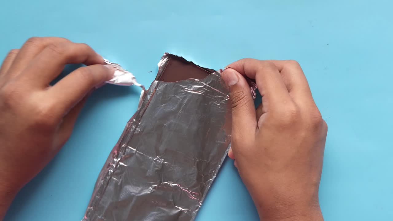 manos desempaquetando una barra de chocolate