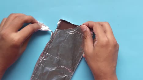 hands unwrapping a chocolate bar