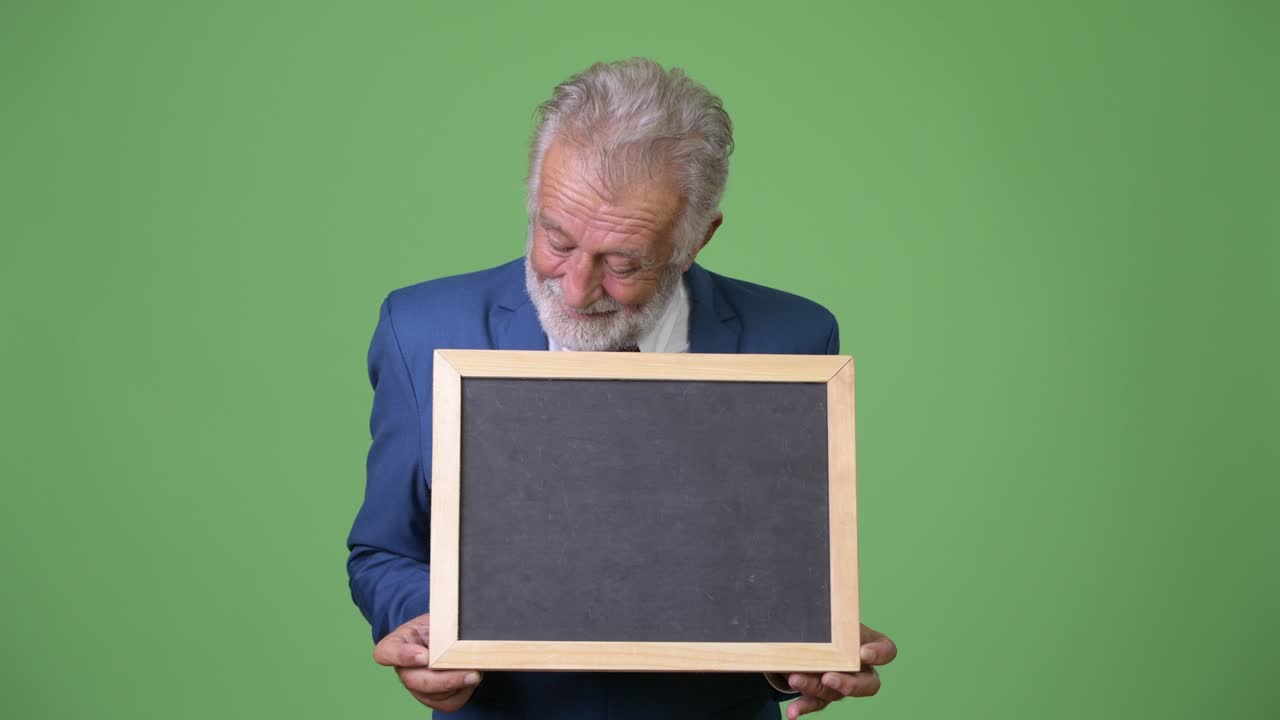 hombre de negocios barbudo y guapo contra un fondo verde.