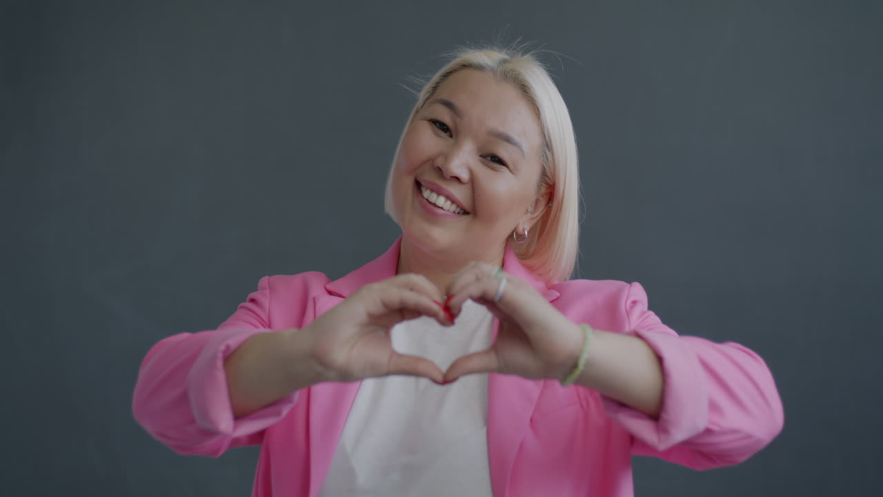 Smiling Woman Making Heart Shape with Hands