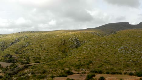 imágenes de drones invertidas que revelan una colina verde y una montaña en el fondo