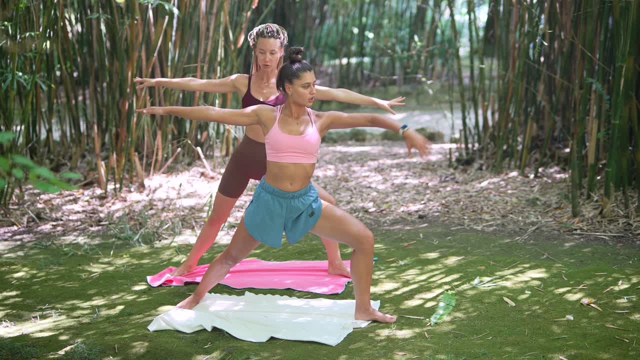Women practicing yoga outdoors in a bamboo forest