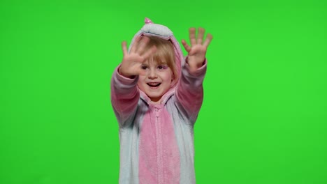 Little-child-girl-smiling,-waving-greeting,-hello-or-bye-with-hand-in-unicorn-pajamas-on-chroma-key