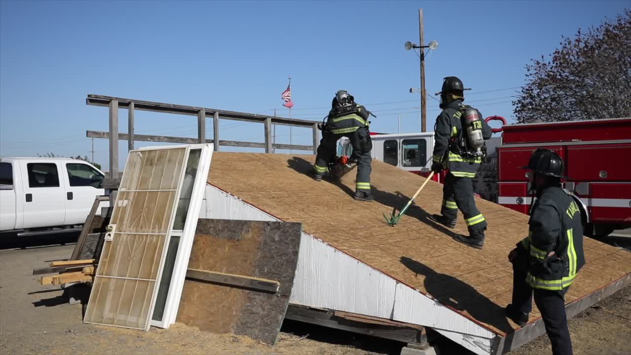 firefighters training by cutting and breaking wood with chainsaw and poker