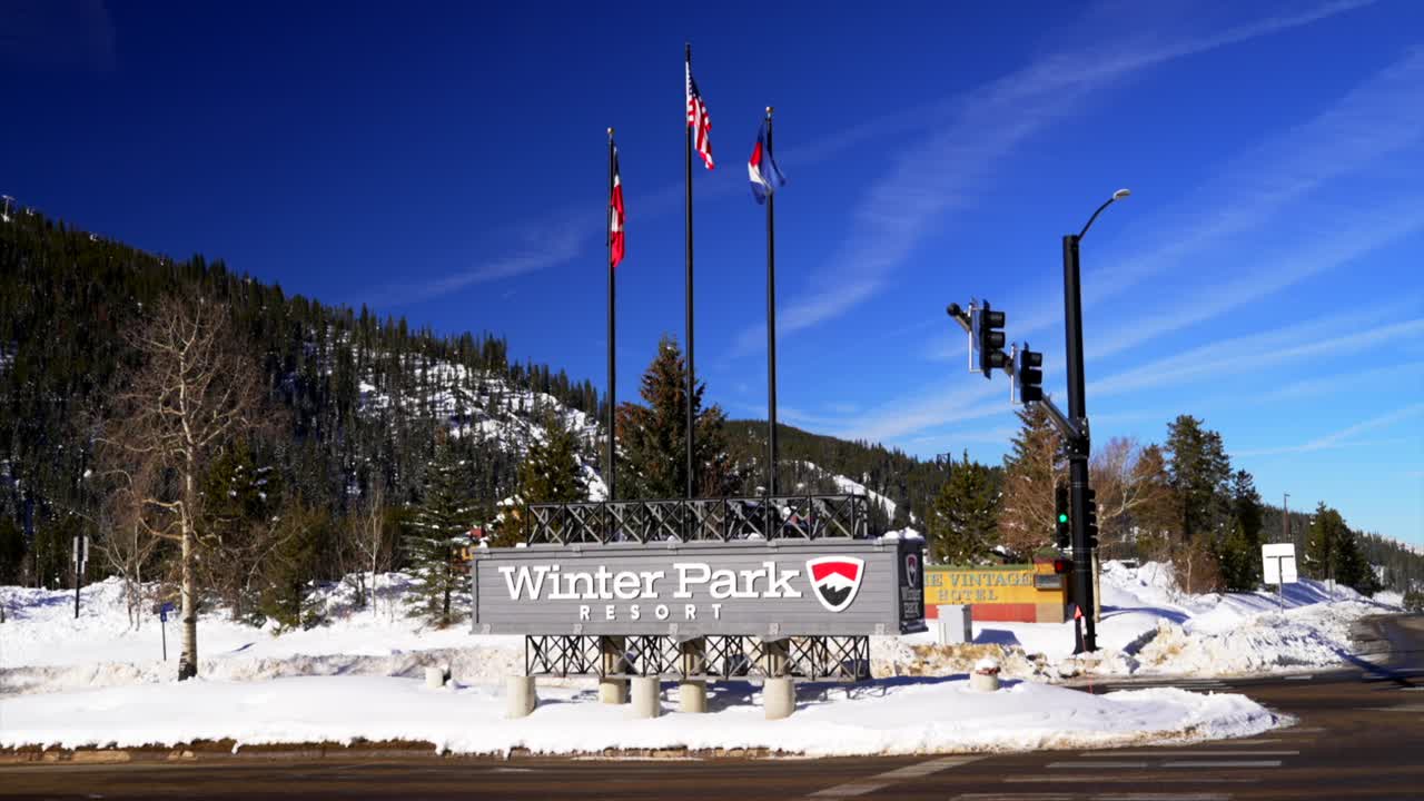 Winter Park Ski Resort early morning December blue sky fresh snow center village entrance still static shot gondola Colorado flags Mary Jane Ski Resort sunny beautiful Rocky Mountain winter day