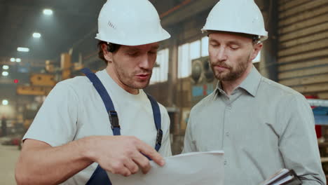 technician and engineer shaking hands, discussing papers at work in factory