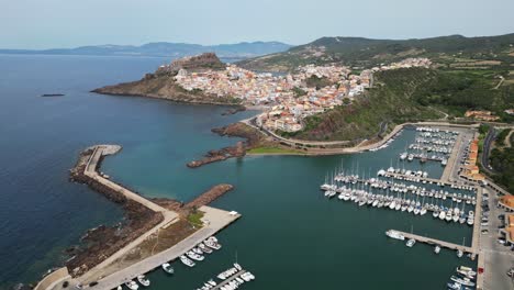 Puerto-De-Castelsardo-Y-Ciudad-Fortificada-En-Cerdeña,-Italia---Círculos-Aéreos-De-Drones-De-4k