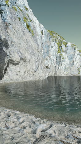 a serene beach with clear water and a rocky cliff in the background