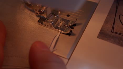 close up of sewing machine foot sewing to the edge and operator releasing the needle