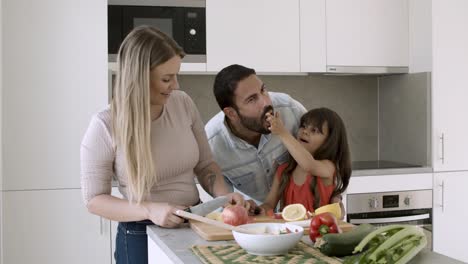 familia feliz cocinando y comiendo en casa