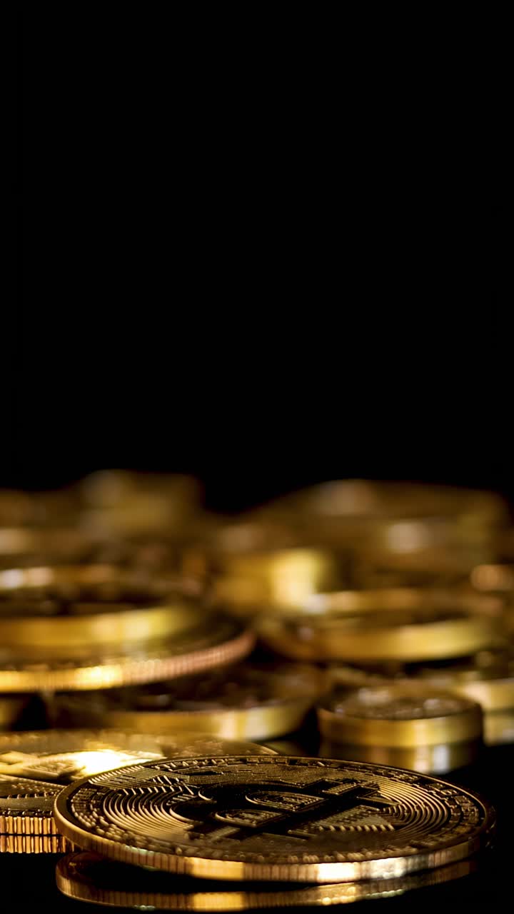 Gold digital coin spins and settles among stacked tokens, dramatic lighting, close-up, shallow focus
