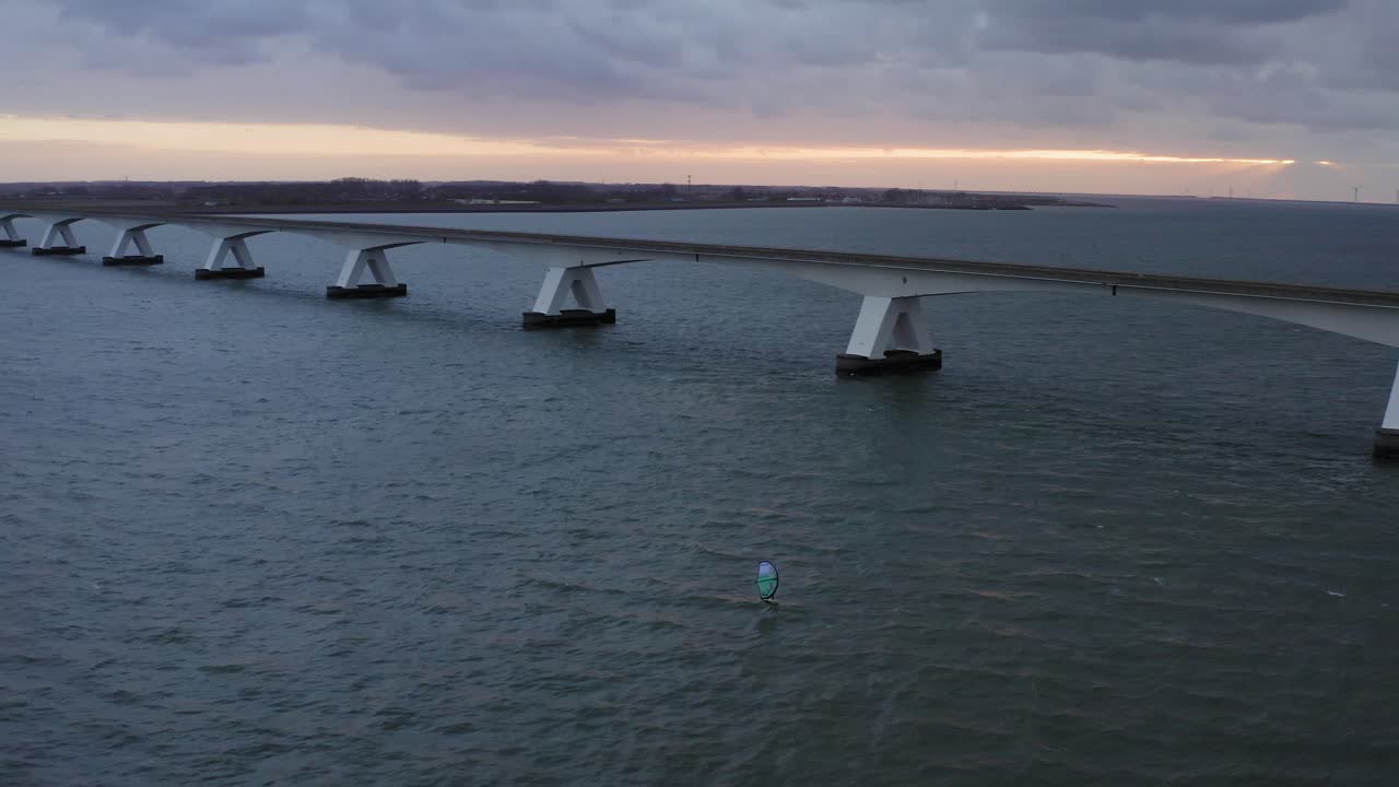 블루 윙 바람이 그 아래에 포일링이 있는 에어포일에 서퍼와 함께 네덜란드에서 가장 긴 젤란트브루그 다리의 공중 와이드 샷