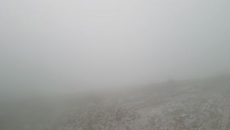 orbit view of man on top of mountain view with thick clouds in montenegro