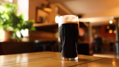 two dark beers clinking in a pub