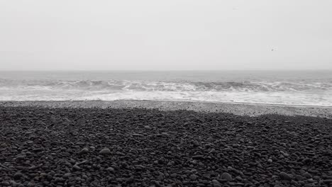 wave splashing at reynisfjara black beach in vik, south iceland