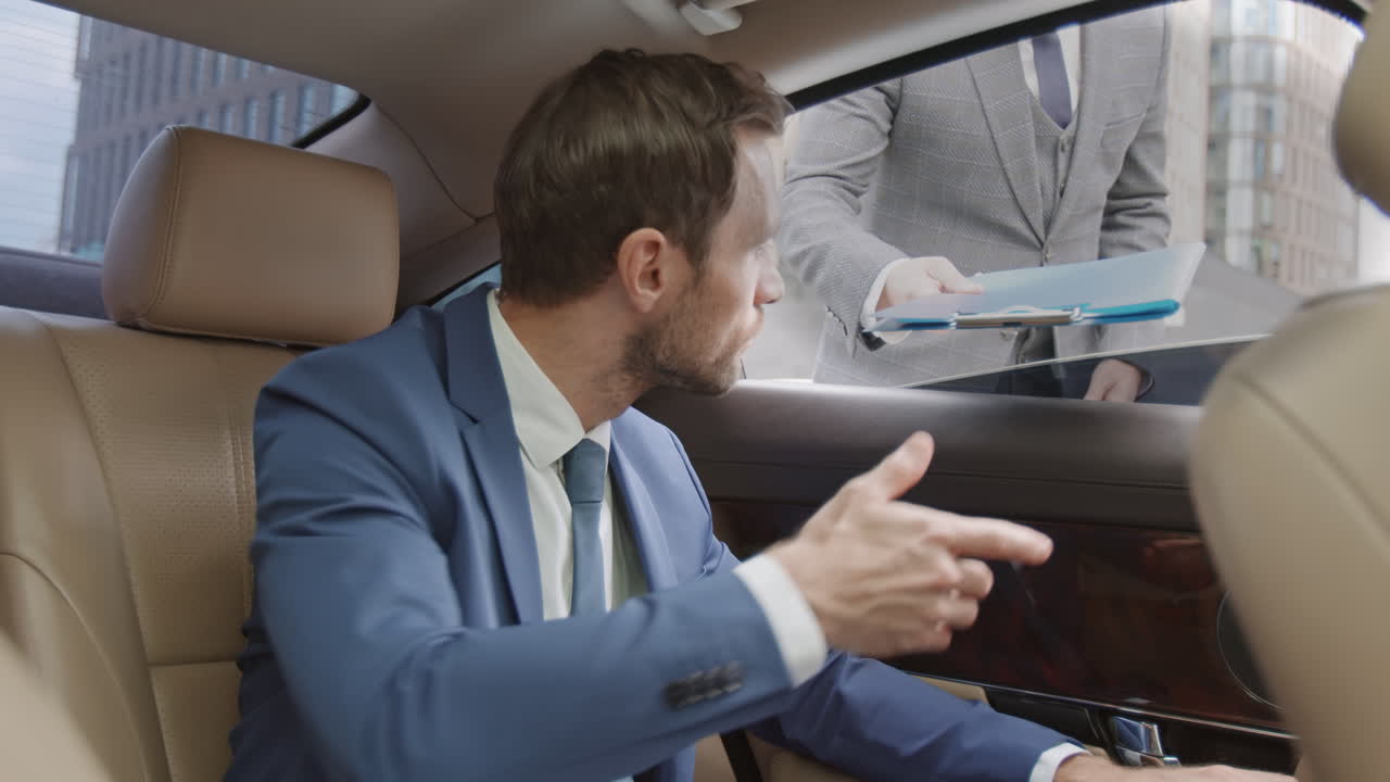 Colleague Giving Folder over Car Window