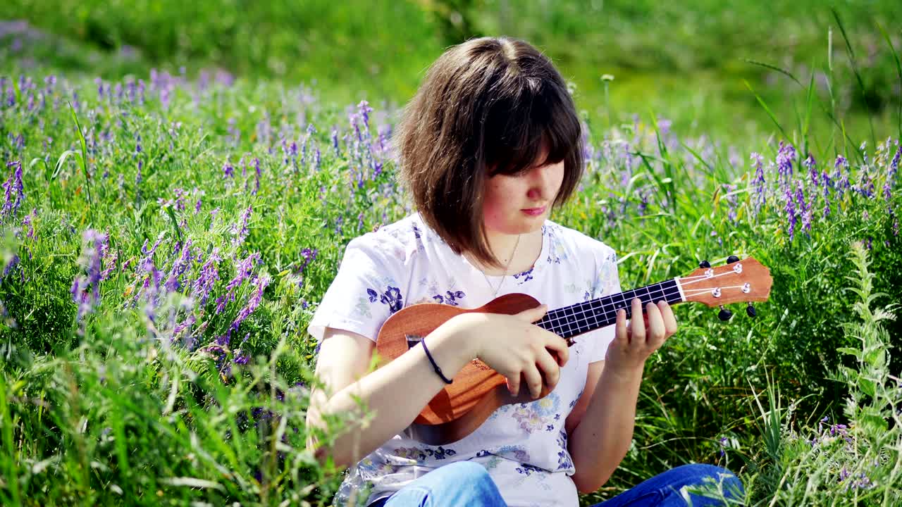 una joven hermosa tocando el ukulele.