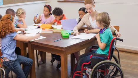 maestra caucásica que enseña a una niña discapacitada en la clase de la escuela