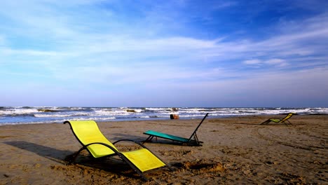 empty beach chairs on a sandy shore