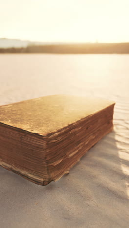 old book on the beach at sunset