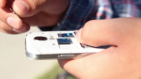 young man checking smartphone memory card close up shoot