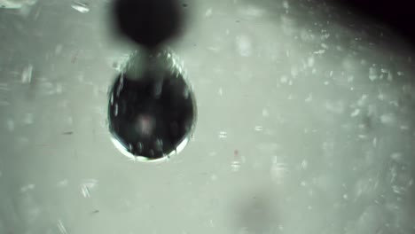 two black spherical bubbles dance play and fight underwater in a sci fi manner science technology