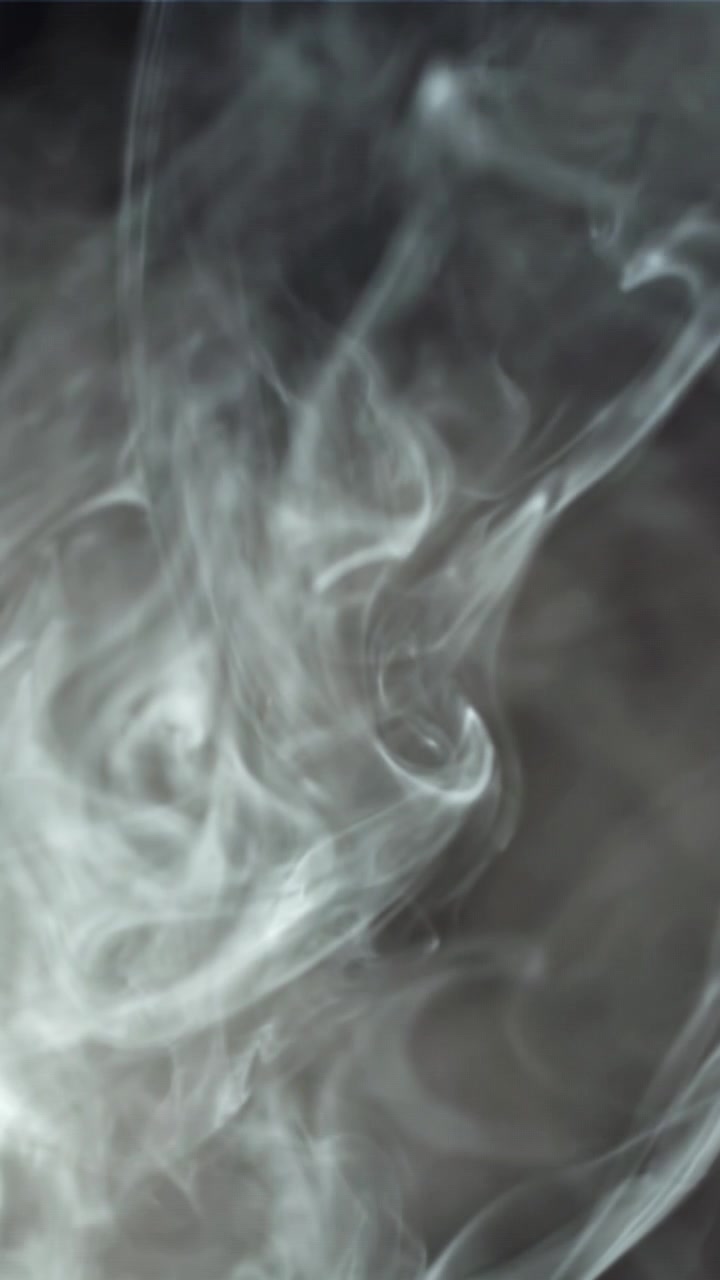 Fumo bianco astratto che turbina e si dissolve su uno sfondo scuro