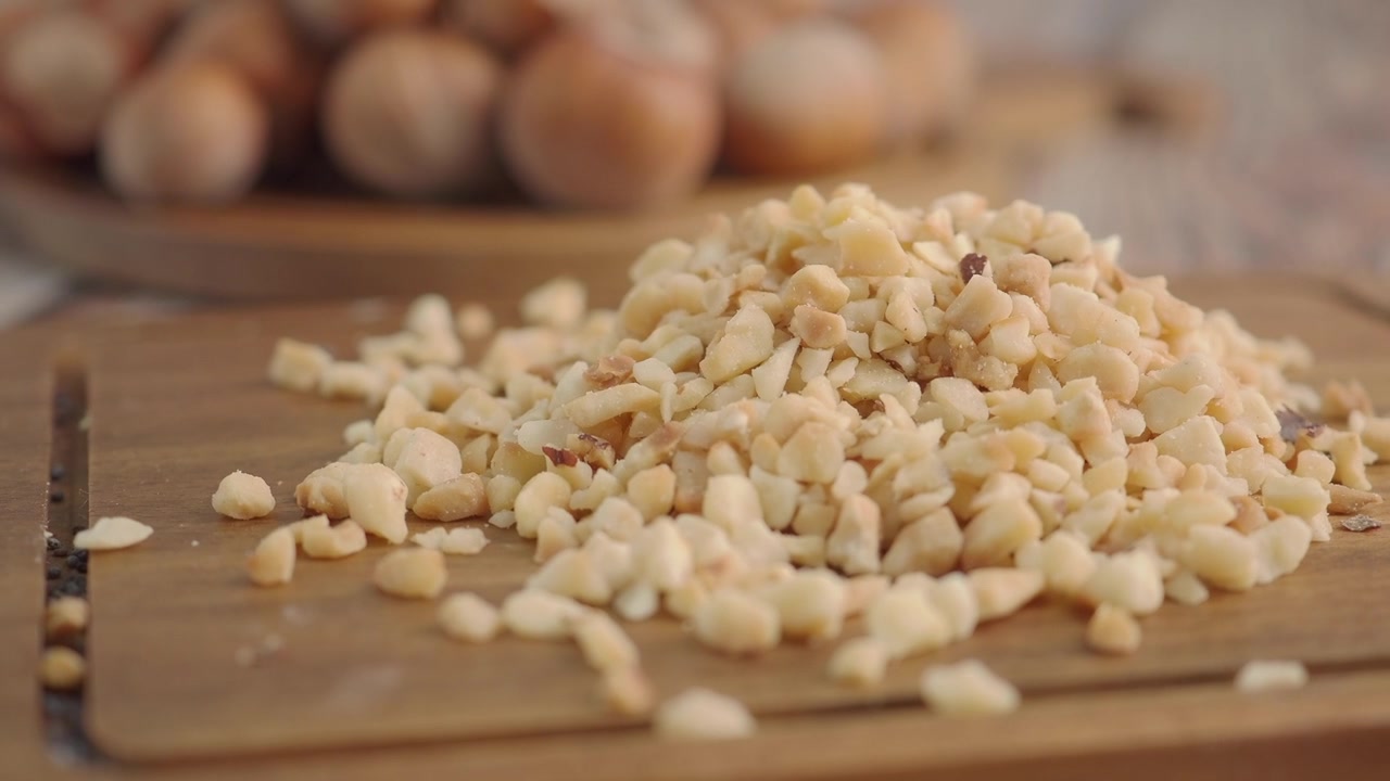 Mucchio di nocciole tritate su un tagliere di legno