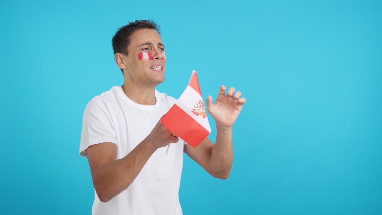 Nervous man cheering for Peru during a match looking away