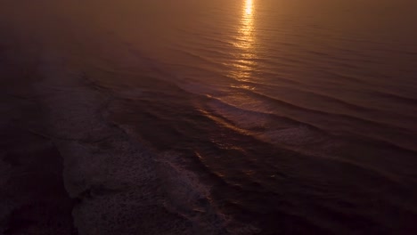Kippbare-Luftaufnahme-Des-Strandes-Bei-Sonnenuntergang,-Wunderschönem-Himmel-Und-Wellen