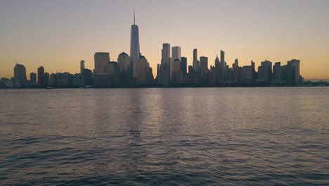 Viaje-Al-Amanecer-A-La-Ciudad-De-Nueva-York,-Resplandor-Matutino-Sobre-La-Torre-De-La-Libertad,-Panorama-Aéreo