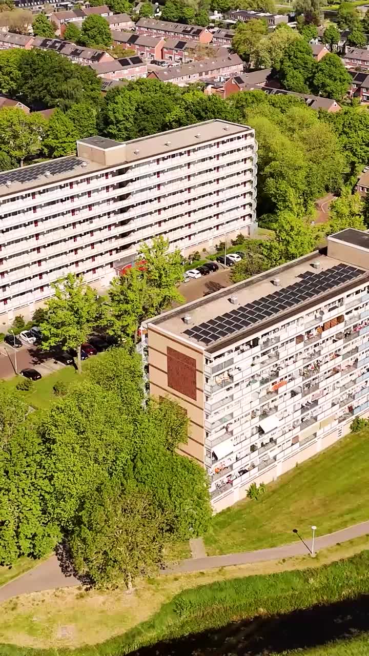 Aerial view of apartment buildings with solar panels and green spaces