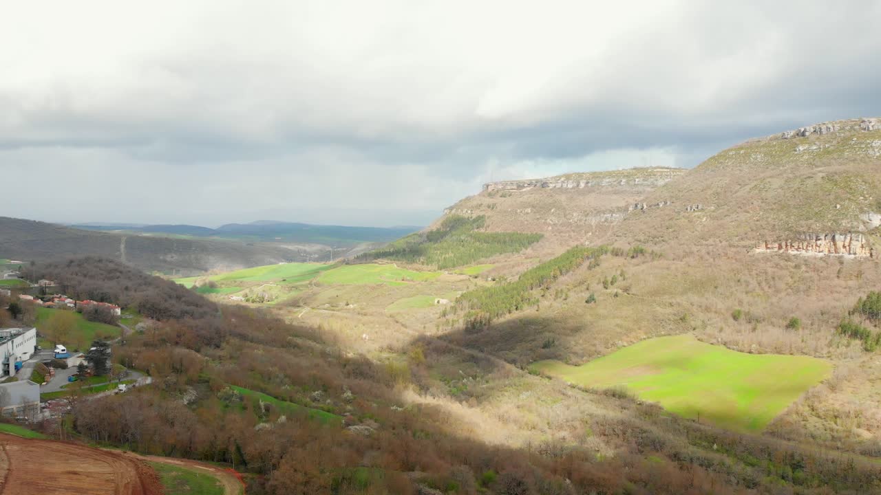 Panoramic View of a Mountain Valley with Green Fields and Forests