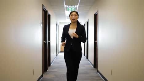 a professional woman strides confidently down the office hallway, embodying focus and determination as she approaches her destination in a corporate environment