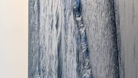 vertical video of small sea waves on the coast