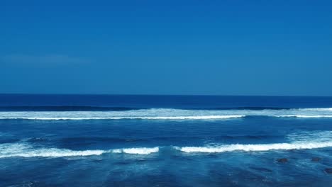 Aerial-footage-filmed-with-a-drone-overlooking-the-beach-and-sea-of-crashing-waves-with-a-deep-blue-ocean-on-the-Bluff-in-Africa-southern-hemisphere